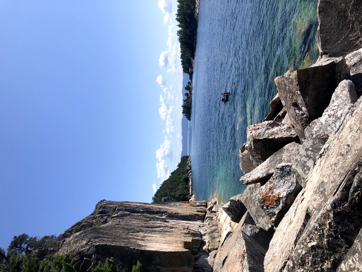 Rock face with canoe along the shore